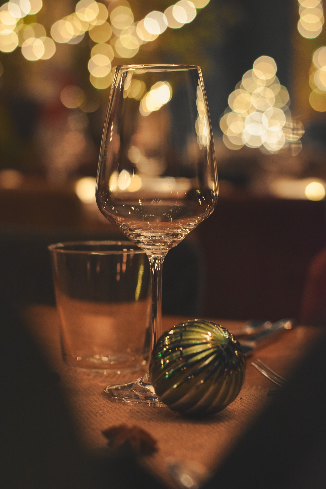 Weinglas mit Weihnachtskugel im Bokeh-Licht – Winterzauber am Fluss